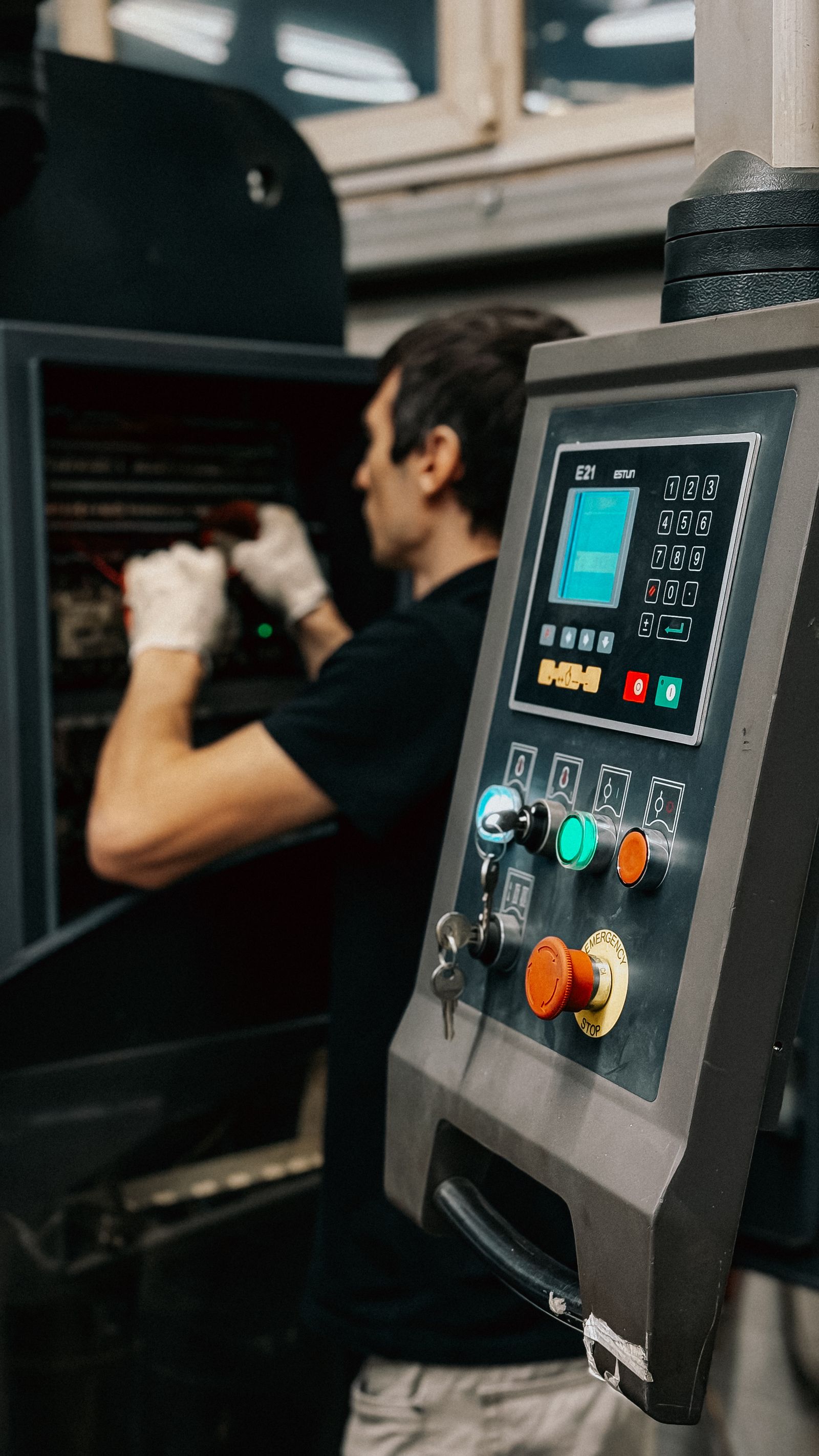 Operator at an industrial machine control panel