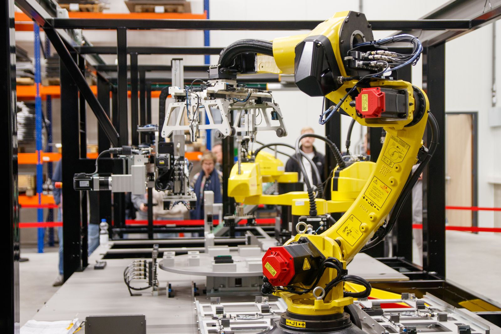Six-axis robot arm inside a guarded work cell